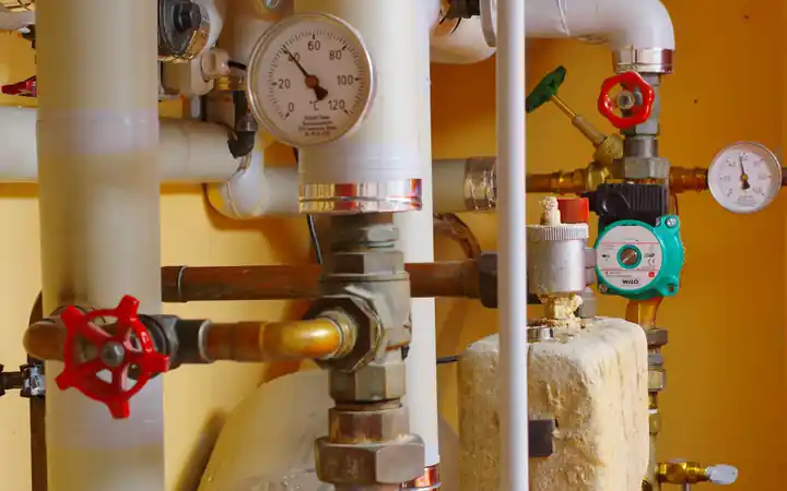Water heater shut-off valve replacement in La Mirada: plumbing pipes with red shut-off valve handles